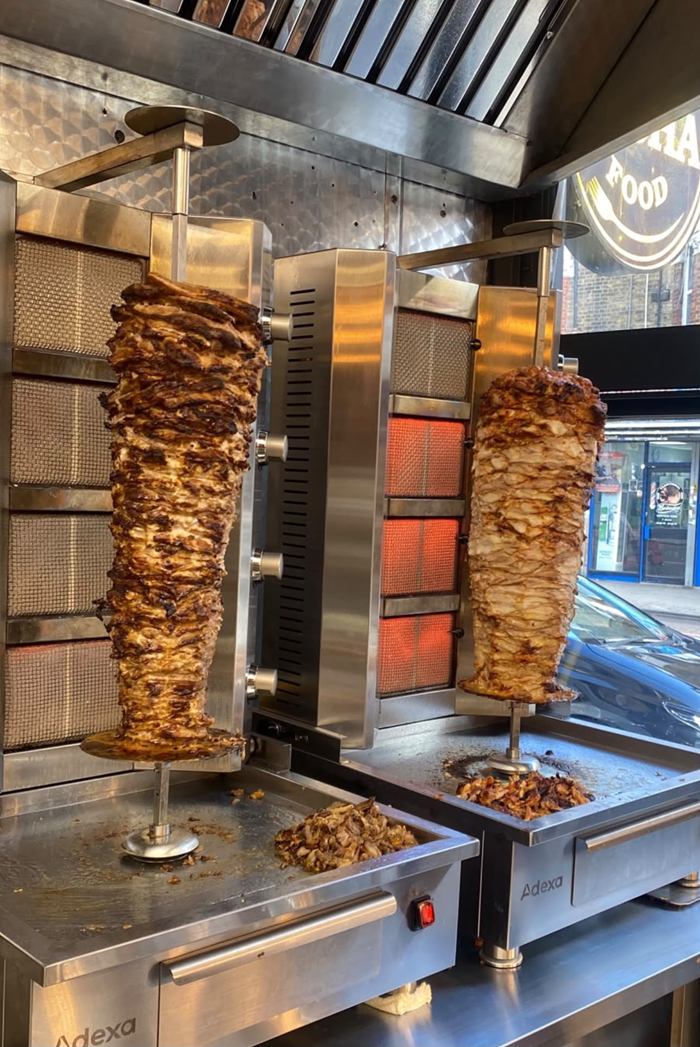 Chicken and lamb shawarma cooking on the rotisserie at Pasha
